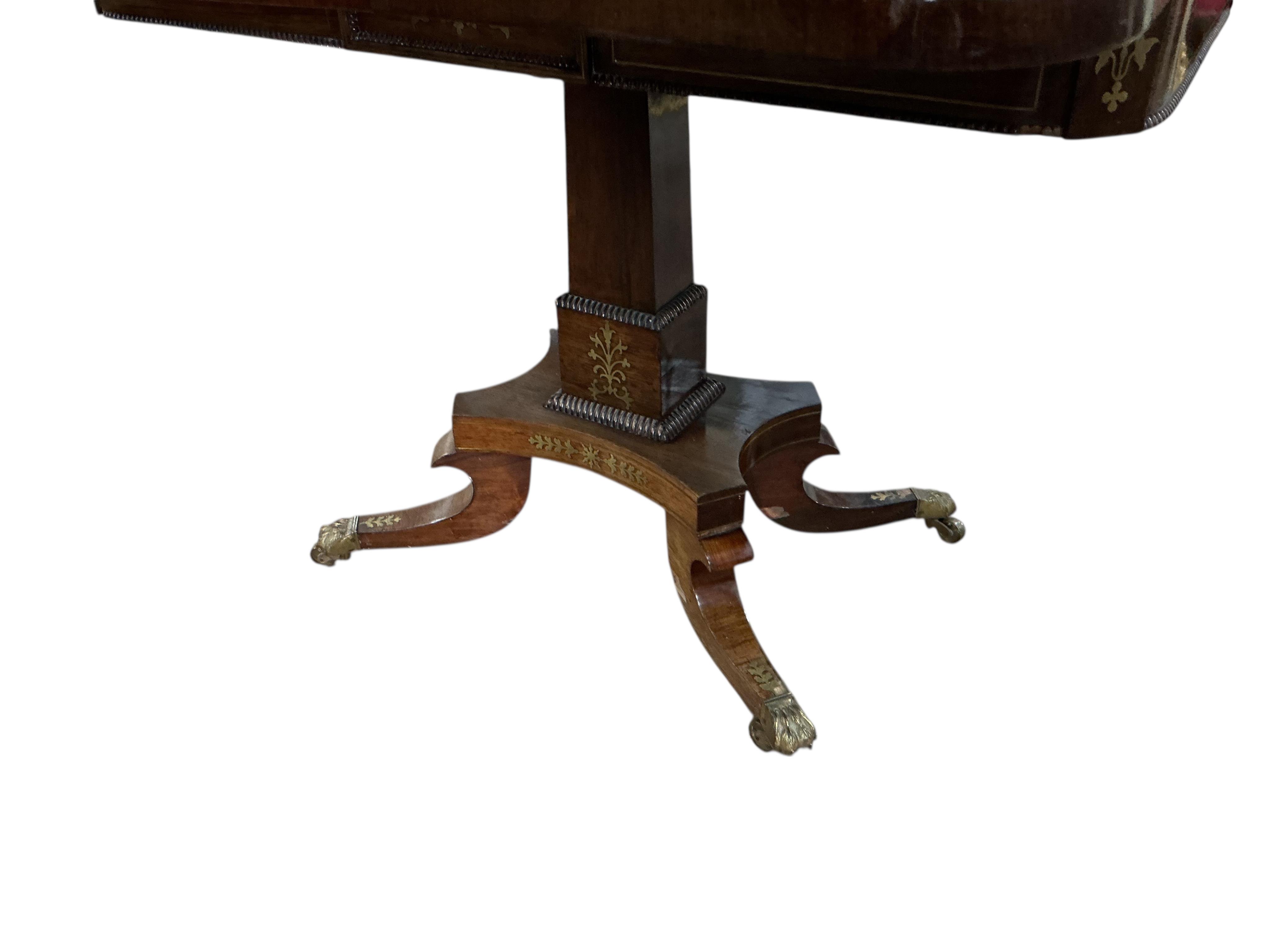 A Regency rosewood and cut brass inlaid pedestal folding card table, width 91cm, depth 45cm, height 73cm